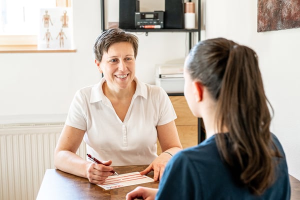 Heilmasseurin Gisela Tösch informiert eine Patientin über die Antragstellung zum Gesundheitshunderter